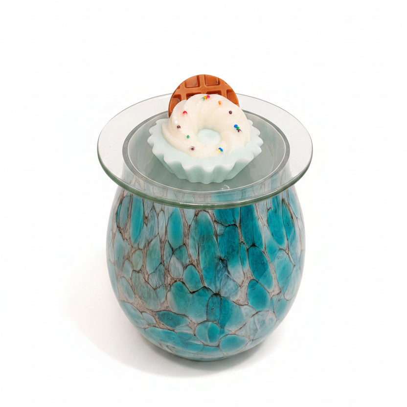 Decorative glass tart warmer with blue marbled design on a kitchen counter.